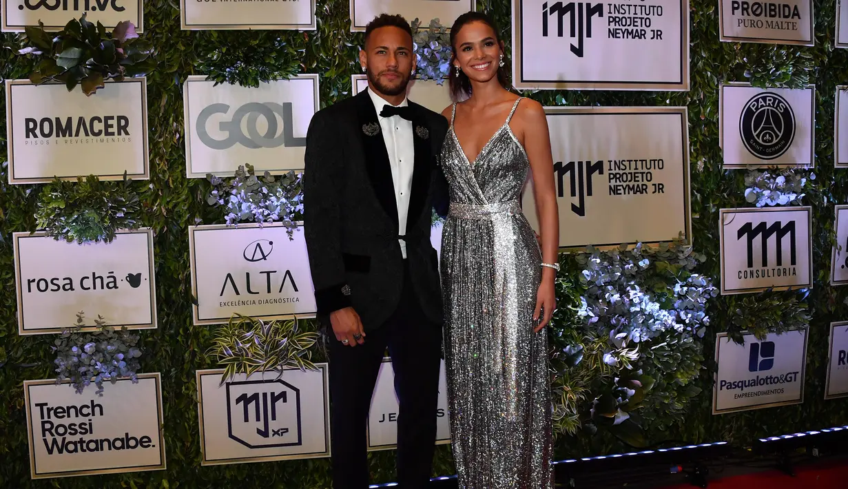 Pemain PSG, Neymar, didampingi sang kekasih, Bruna Marquezine, saat menghadiri acara amal untuk Institut Neymar Jr di Sao Paulo, Brasil, Kamis (19/7/2018). Bintang asal Brasil itu tampak menawan dengan balutan jas. (AFP/Nelson Almeida)