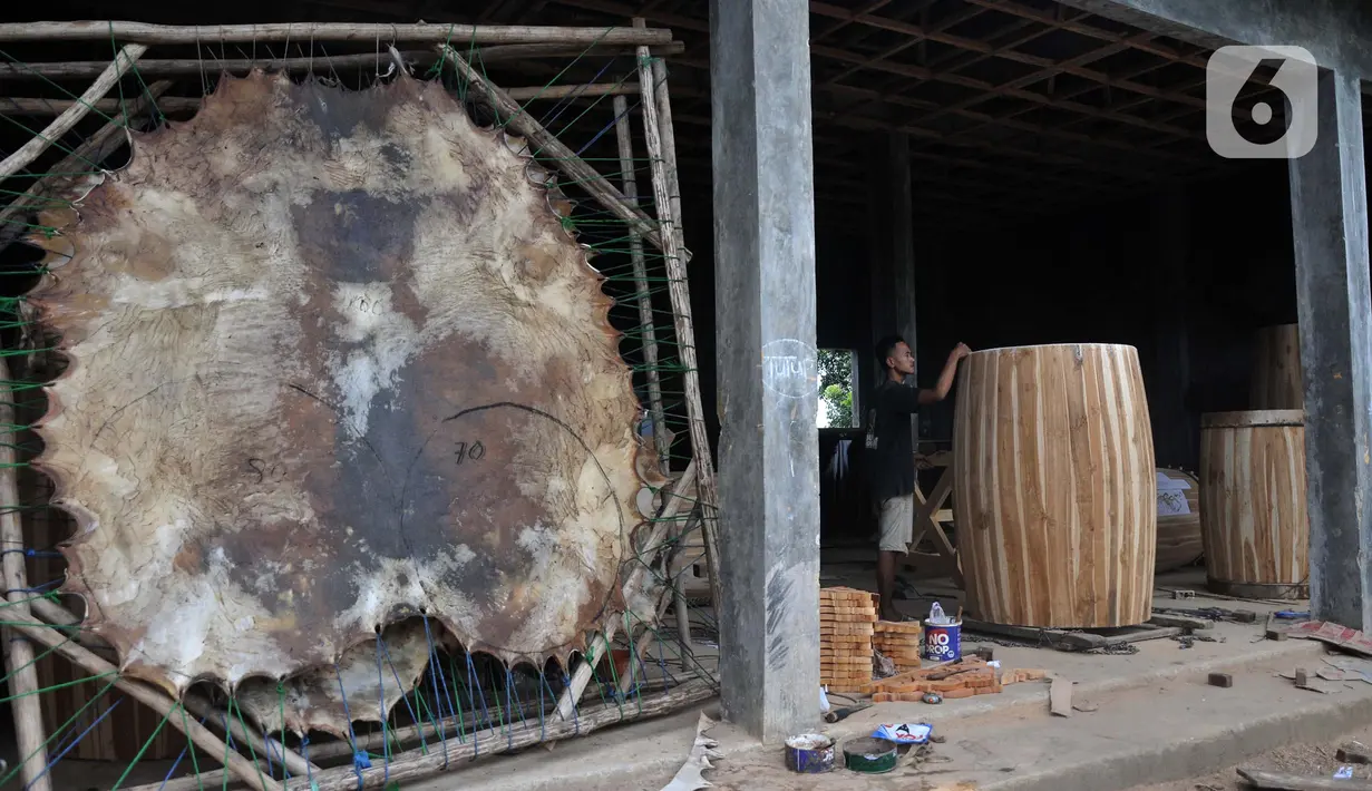 <p>Perajin menyelesaikan pembuatan beduk Al Mubarok di Desa Gumulung, Kecamatan Greged, Kabupaten Cirebon, Jawa Barat pada akhir Maret 2022 lalu.Untuk pembuatan beduk raksasa berbahan kayu jati ini biasanya dapat diselesaikan dalam seminggu. Beduk Al Mubarok dijual mulai dari Rp7 juta untuk ukuran 60cmx100cm hingga ratusan juta rupiah untuk ukuran yang lebih besar, tergantung jenis kayu dan kulit. (merdeka.com/Iqbal S Nugroho)</p>