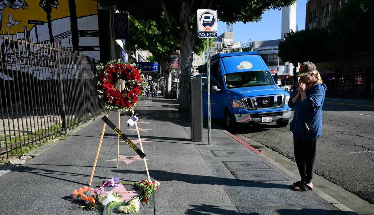 Rob Reiner, seorang aktor, sutradara, sekaligus produser legendaris Amerika Serikat ditemukan tewas bersama istrinya, Michele Singer Reiner, di kediaman mereka di Brentwood, Los Angeles pada Minggu (14/12/2025) sore waktu setempat. Tampak dalam foto, seorang wanita memberi penghormatan di dekat bintang Hollywood Walk of Fame milik aktor sekaligus sutradara Amerika Serikat, Rob Reiner, di Los Angeles, California, pada Senin 15 Desember 2025. (Frederic J. Brown/AFP)