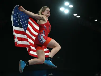 Pegulat Amerika Amit Elor berselebrasi dengan bendera nasionalnya setelah mengalahkan Meerim Zhumanazarova dari Kirgistan pada final gulat nomor freestyle 68kg putri Olimpiade Paris 2024 di Champ-de-Mars Arena, Selasa (6/8/2024). (Punit PARANJPE / AFP)