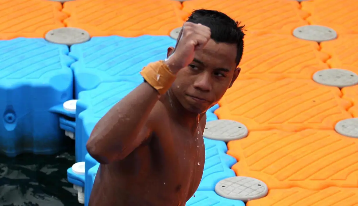 Aflah Fadlan Prawira atlet Renang Perairan Terbuka Putra 10 km Jawa Barat mendarat usai laga PON XX Papua di Teluk Yos Sudarso Jayapura, Selasa (5/10/2021). (Foto PB PON XX/Ardy Alvez)