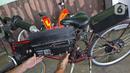 Mujahid (60) memasang aki sepeda listrik sigma buatannya di Pondok Gede, Bekasi, Jawa Barat, (15/9/2020). Sepeda listrik sigma berkapasitas 1.000 watt tersebut mampu menempuh jarak 60 Km dengan harga perakitan sebesar Rp 10 Juta. (Liputan6.com/Herman Zakharia)