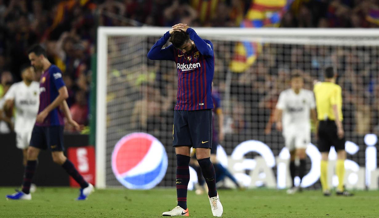 Bek Barcelona, Gerard Pique, tampak kecewa usai dikalahkan Valencia pada laga Copa del Rey di Stadion Benito Villamarin, Sevilla, Sabtu (25/5). Barcelona kalah 1-2 dari Valencia. (AFP/Pau Barrena)