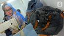 Perajin Risma Eljundi menyelesaikan pembuatan tas dari bahan celana jeans bekas di Legok, Tangerang, Banten, Senin (11/11/2019). Tas berbahan jeans itu dipasarkan ke kawasan Bandung serta pasar daring. (merdeka.com/Arie Basuki)