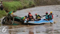Prajurit TNI dan sukarelawan menyisir bangkai mobil yang diduga terdapat jenazah korban musibah banjir bandang di Cimacan, Garut (23/9). Data terakhir, korban jiwa mencapai 26 orang dan warga yang dilaporkan hilang 23 orang. (Liputan6.com/Johan Tallo)