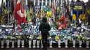 Seorang warga setempat berdiri di depan tugu peringatan sementara untuk tentara Ukraina di Lapangan Kemerdekaan, Kyiv, saat peringatan keempat invasi Rusia ke Ukraina, Selasa 24 Februari 2026. Hari ini, perang Rusia-Ukraina yang pecah pada 24 Februari 2022 telah berlangsung selama empat tahun. (HENRY NICHOLLS/AFP)