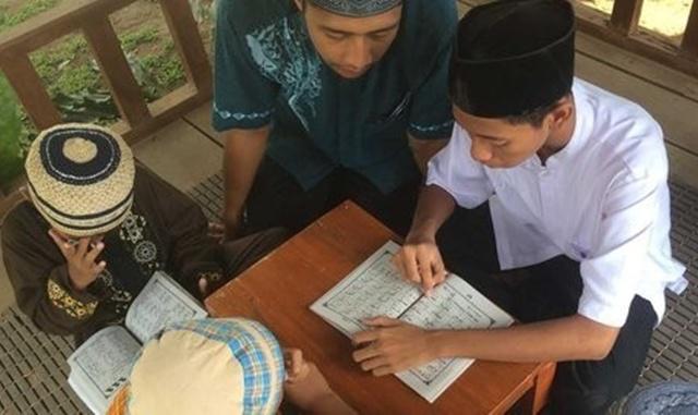 Anak tunarungu sedang belajar membaca Al Quran dimulai dari belajar Iqro | Copyright by merdeka.com