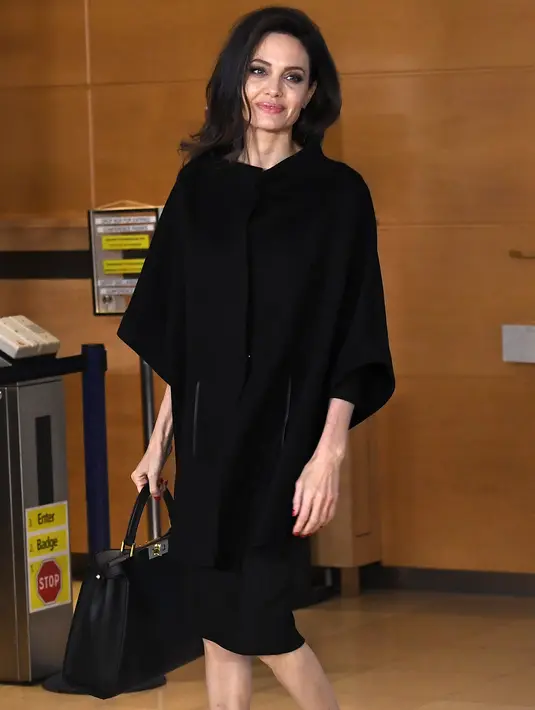 Penampilan Aktris dan Duta UNHCR, Angelina Jolie saat mengunjungi Markas Besar NATO di Brussels, Belgia (31/1). Angelina Jolie tampil cantik dengan busana dan sepatu warna hitam. (AFP Photo/Emmanuel Dunand)