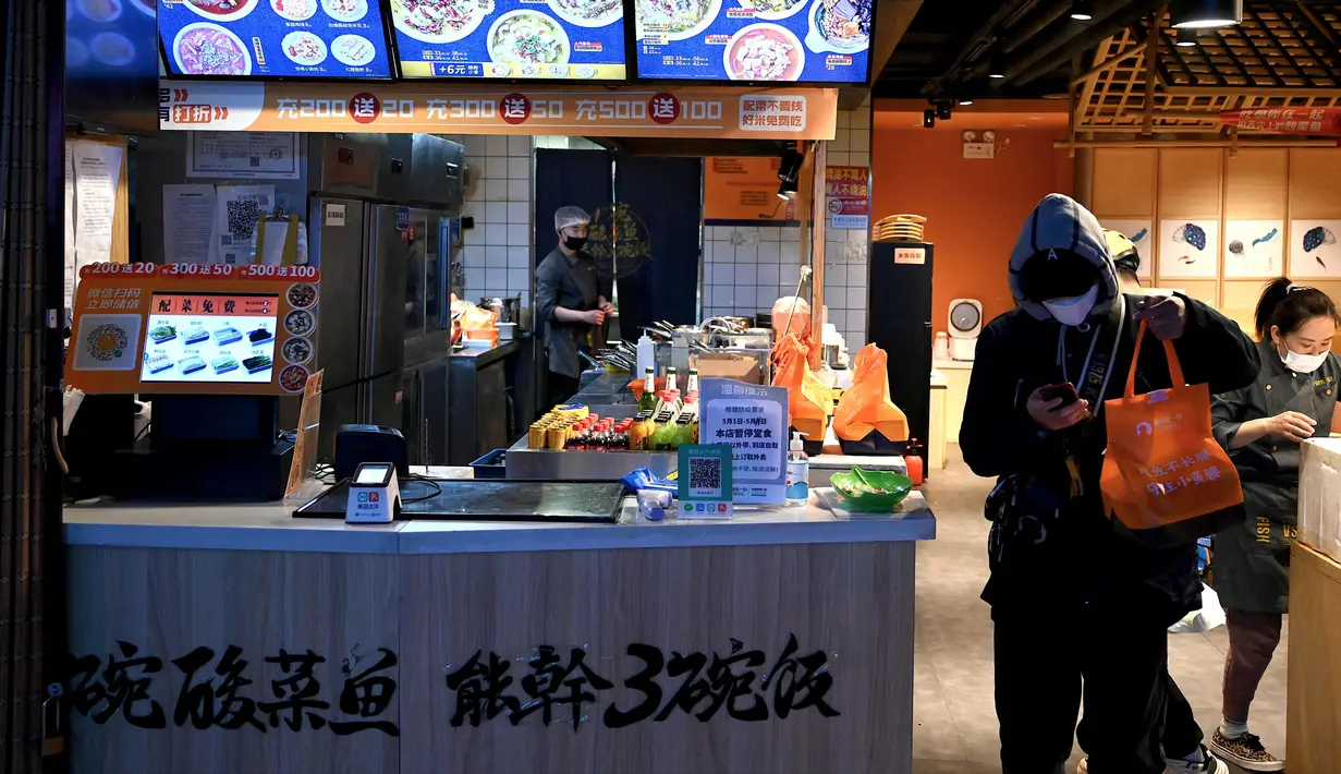 <p>Seorang pekerja pengiriman mendapat pesanan makanan untuk dibawa pulang ketika pemerintah melarang makan di restoran untuk mengekang penyebaran virus corona COVID-19 di Beijing, China, Selasa (10/5/2022). Jutaan orang di Beijing tinggal di rumah pada 9 Mei ketika Ibu Kota China tersebut mencoba untuk menangkis wabah COVID-19 dengan pembatasan pergerakan. (Noel Celis/AFP)</p>