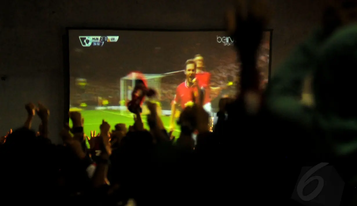 Suporter Manchester United bersorak saat menyaksikan penyerang "The Red Devils", Juan Mata berhasil membobol gawang Liverpool pada acara nonton bareng di Tanah Kusir, Jakarta (14/12/2014). (Liputan6.com/Helmi Fithriansyah)