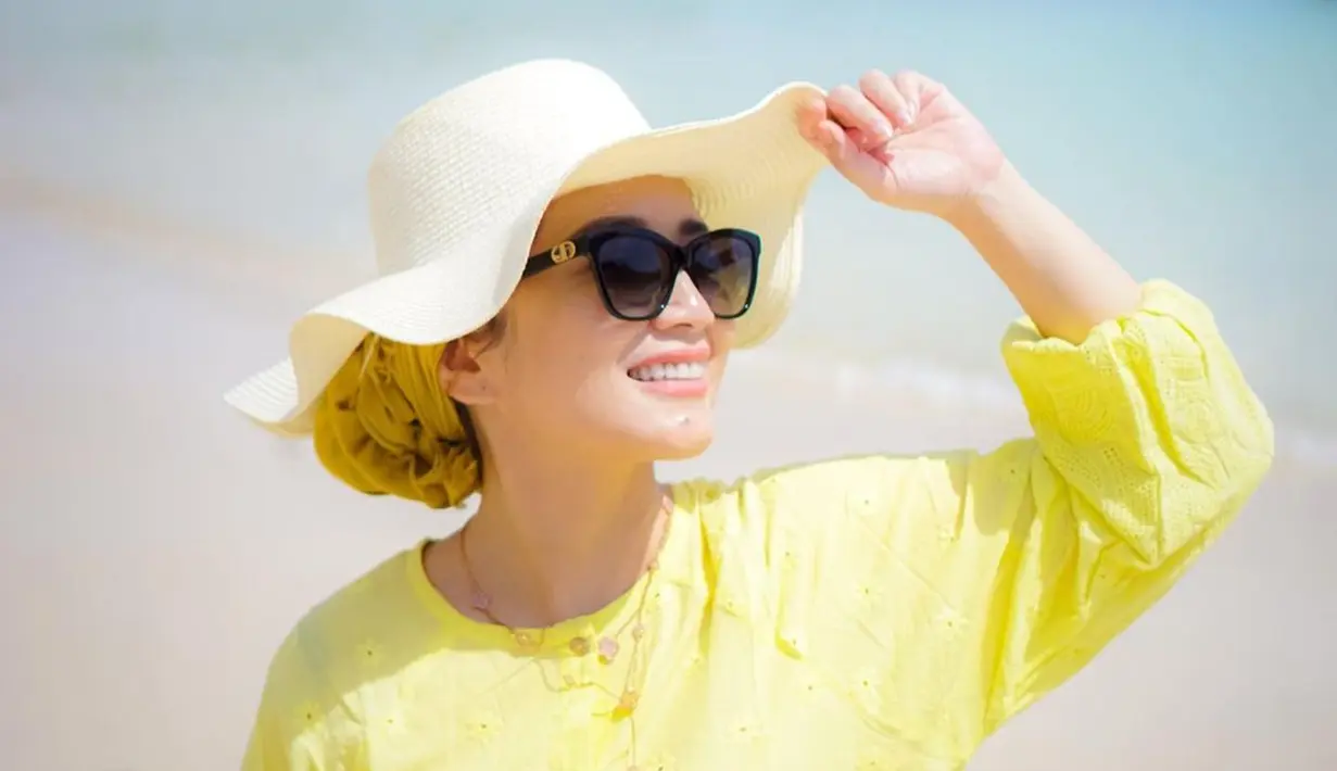 Dine Mutiara tampil memesona dengan topi dan kacamata di pantai. Baju kuningnya juga kian memperlihatkan sisi cerah dari istri Sahrul Gunawan. Potret cantiknya ini banjir pujian dari warganet. (Liputan6.com/IG/dine.pearl)