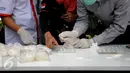 Petugas BNN melakukan uji lab lapangan barang bukti jenis sabu yang disita dari dua kelompok pengedar di Gedung BNN Jakarta, Kamis (29/10/2015). Sabu seberat 22,4 kg dimusnahkan BNN dihadapan sejumlah saksi dan tersangka. (Liputan6.com/Helmi Fithriansyah)