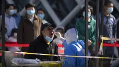 Seorang pekerja yang mengenakan alat pelindung diri menyeka tenggorokan seorang pria saat tes COVID-19 di tempat pengujian setelah pihak berwenang memerintahkan putaran ketiga dari tiga tes COVID-19 berturut-turut untuk penduduk di Distrik Chaoyang, Beijing, China, Sabtu (7/5/2022). (AP Photo/Mark Schiefelbein)