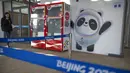 Seorang anggota staf berjalan melewati mural maskot Olimpiade Bing Dwen Dwen di Desa Olimpiade Musim Dingin, Beijing, China, Jumat, 24 Desember 2021. Olimpiade dan Paralimpiade Musim Dingin 2022 akan diadakan mulai bulan Februari. (AP Photo/Mark Schiefelbein)