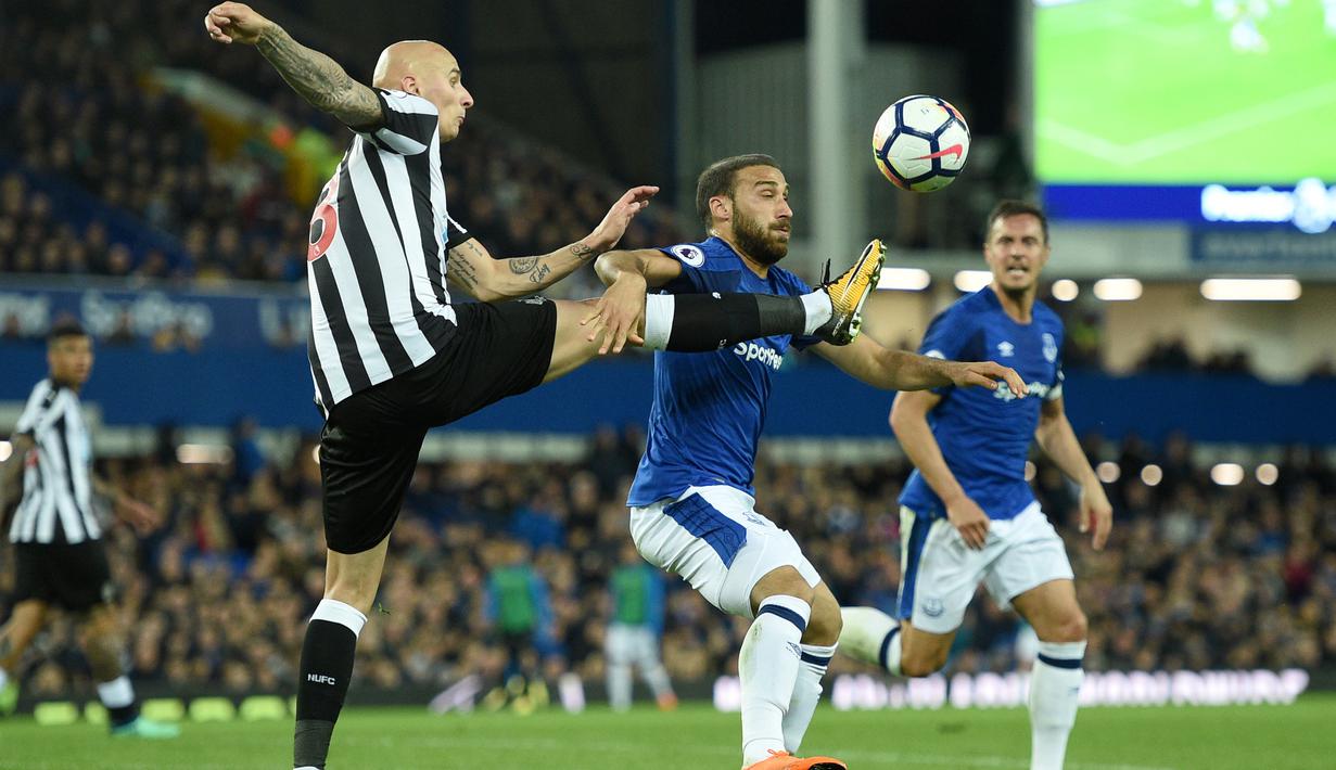 Pemain Newcastle United, Jonjo Shelvey (kiri) menghalau bola dari kejaran pemain Everton, Cenk Tosun pada lanjutan Premier League di Goodison Park, Liverpool,(23/4/2018). Everton menang 1-0. (AFP/Oli Scarff)