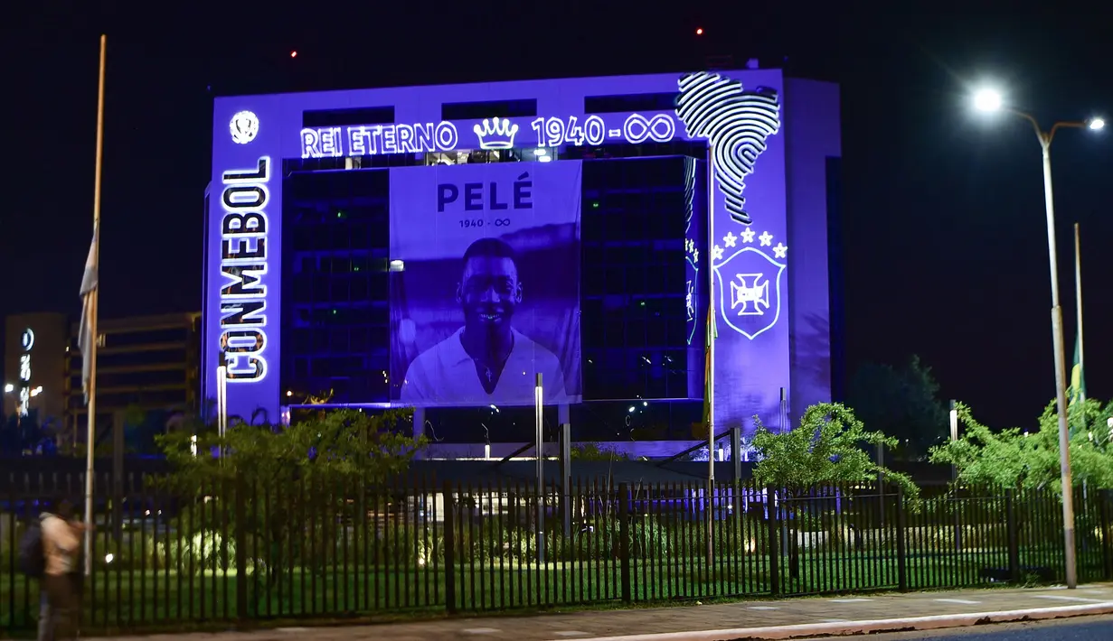 Gambar mendiang legenda sepak bola Brasil, Pele terlihat di fasad markas Conmebol (Konfederasi Sepak Bola Amerika Selatan) di Luque, Paraguay, pada 29 Desember. 2022. Sebelum kepergiannya, Pele menjalani perawatan intensif di rumah sakit Albert Einstein, Sao Paulo selama satu bulan terakhir untuk berjuang sembuh dari kanker usus yang dideritanya sejak 2021. (AFP/Norberto Duarte)