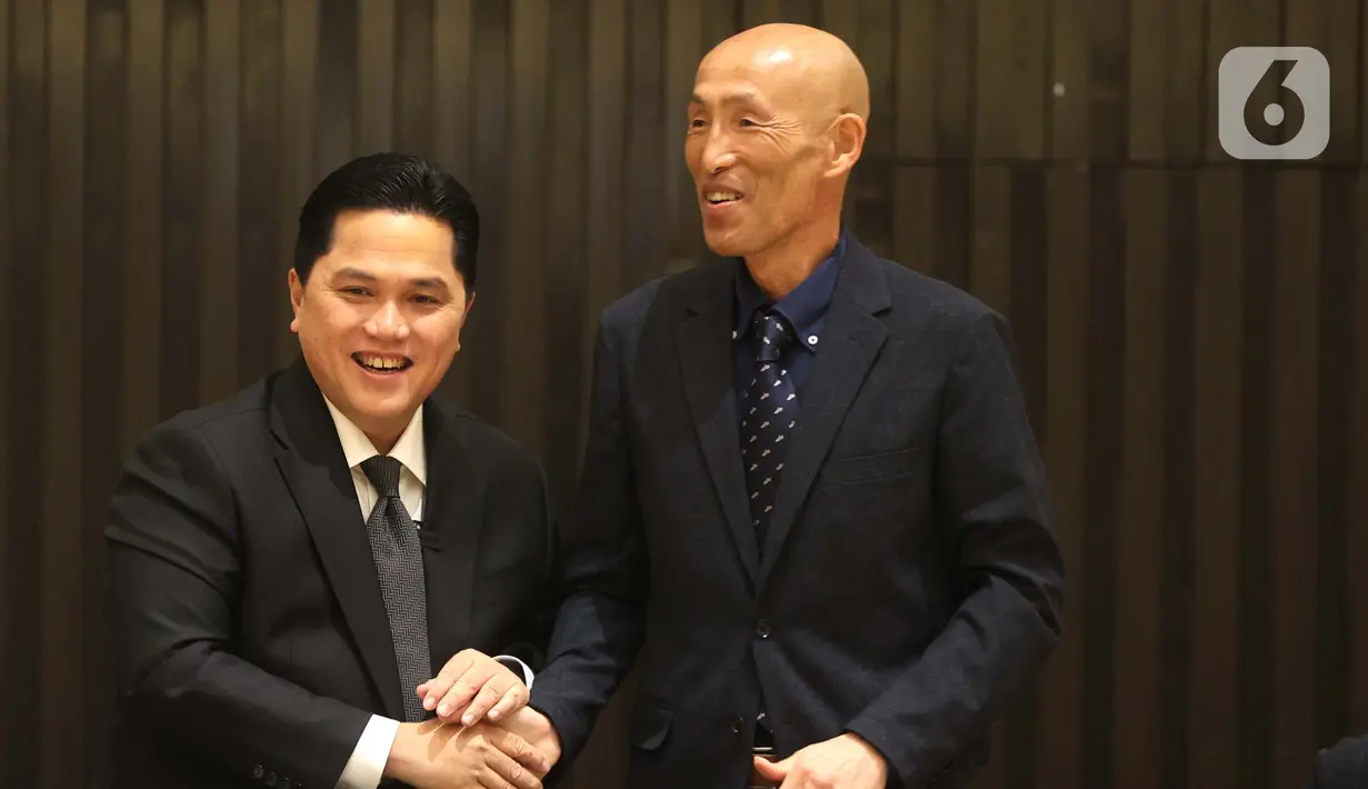 Ketua Umum PSSI Erick Thohir (kiri) bersalaman dengan pelatih asal Jepang, Satoru Mochizuki usai memberi sejumlah keterangan di Jakarta, Selasa (20/2/2024). (Bola.com/ Muhammad Iqbal Ichsan)