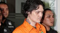 Anak musisi Ahmad Albar, Ozzy Albar dibawa petugas kepolisian seusai rilis kasus Narkoba di Polda Metro Jaya, Jakarta, Kamis (13/9). Ozzy ditangkap di sebuah ATM di Jalan Wolter Monginsidi dengan barang bukti ganja 2,66 gram. (Liputan6.com/Faizal Fanani)