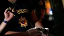 Petugas memeriksa pistol yang berada di dekat jenazah pria diduga bandar narkoba di pinggir jalan Malate, Manila (29/8). Kondisi jenazah ini sama seperti tragedi sebelumnya, yakni luka tembak dan pistol di tangan. (REUTERS/Romeo Ranoco)