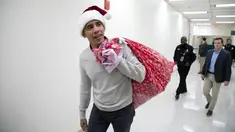 Mantan Presiden AS, Barack Obama mengunjungi Children's National Medical Center di Washington, Rabu (19/12). Dengan topi khas merah putih ala sinterklas, Obama membagikan hadiah natal untuk anak-anak yang sedang menjalani perawatan. (Chuck Kennedy / AFP)