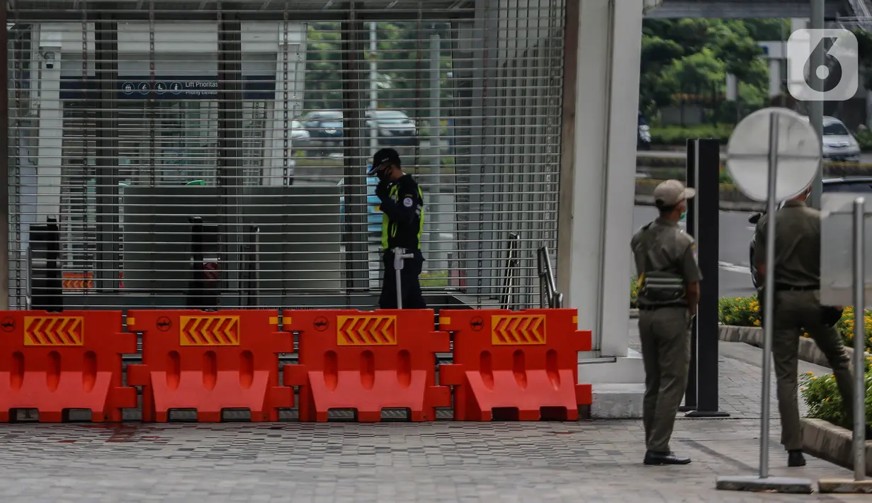Petugas berjaga di pintu masuk Stasiun MRT Setiabudi yang tutup, Jakarta, Senin (27/4/2020). PT MRT Jakarta menutup dua stasiun MRT yang merupakan lanjutan dari penutupan lima stasiun sebelumnya guna mendukung penerapan Pembatasan Sosial Berskala Besar (PSBB) Jakarta. (Liputan6.com/Faizal Fanani)