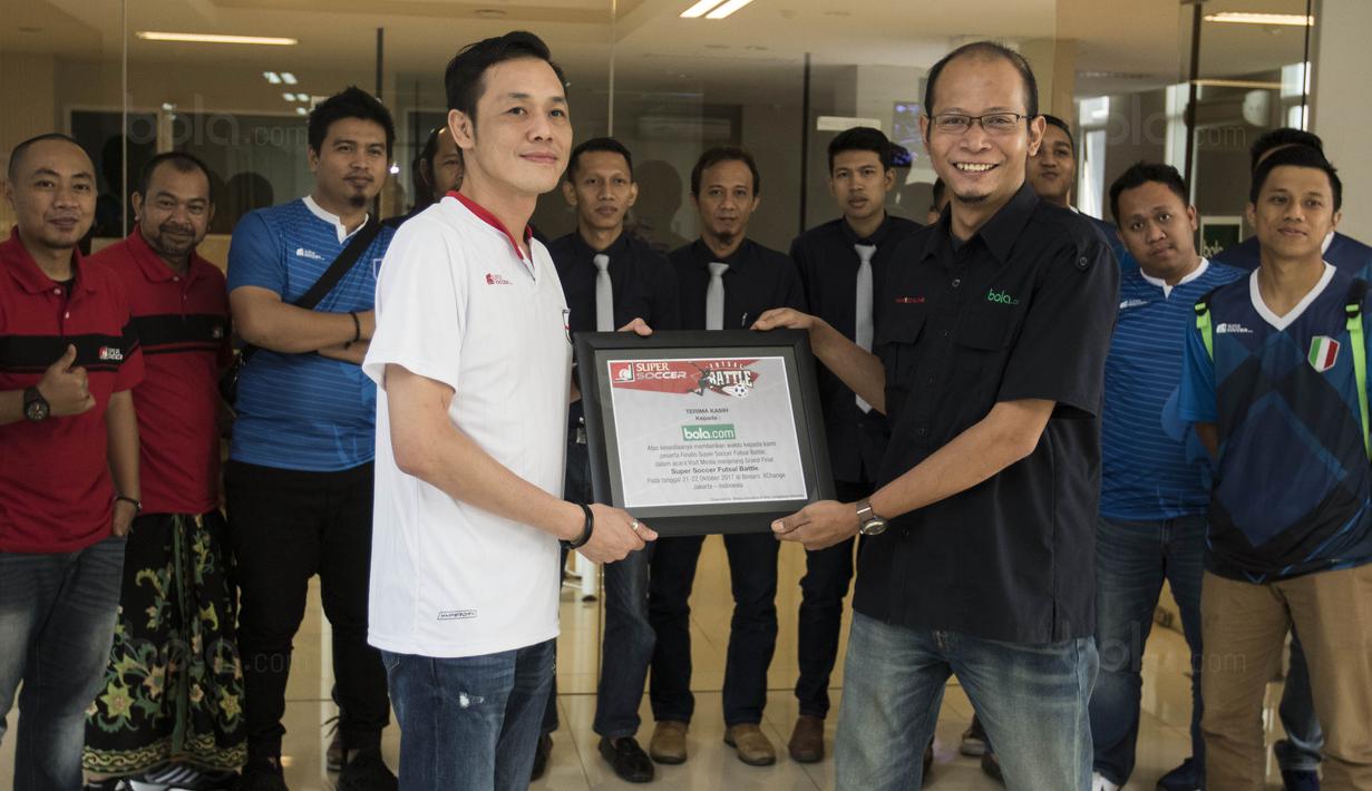 Perwakilan Super Soccer, Ignatius Budi Hariyanto, memberikan plakat kepada Redpel Bola.com, Tjatur Wiharyo usai media visit di Kantor Redaksi Bola.com, Jakarta, Selasa (17/10/2017). (Bola.com/Vitalis Yogi Trisna)