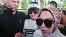 Penyanyi Syahrini (tengah) saat mendatangi Bareskrim Mabes Polri untuk menjalani pemeriksaan, Jakarta, Rabu (27/9). Ia datang mengenakan setelan kasual yakni kaus putih, celana jeans, dan topi bermerek GUCCI. (Liputan6.com/Helmi Afandi)
