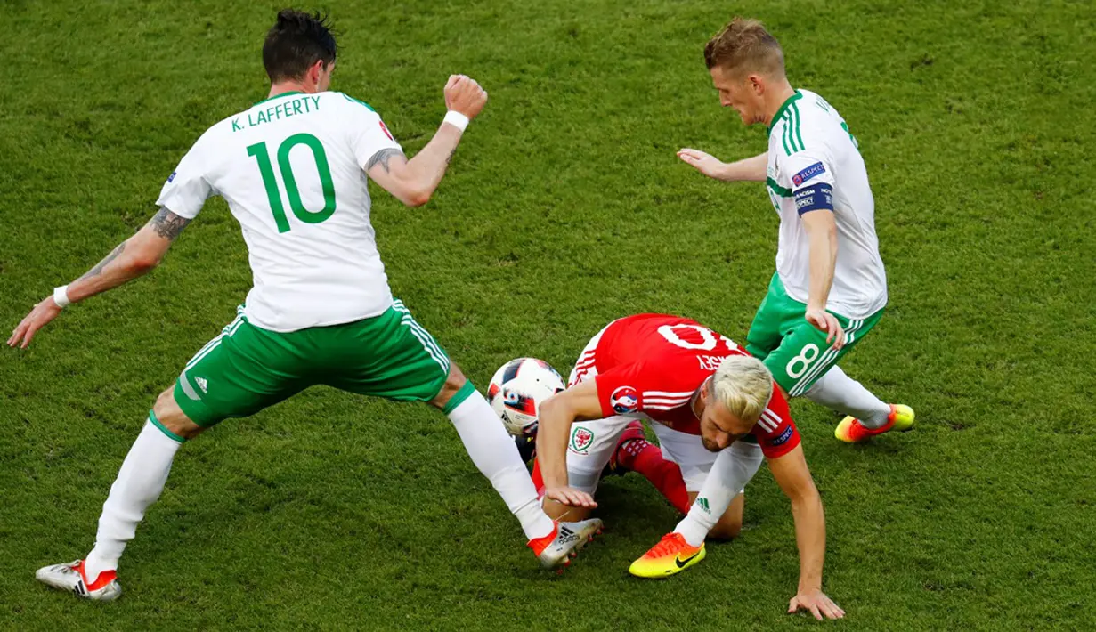 Pergerakan pemain Wales, Aaron Ramsey, dihadang dua pemain Irlandia Utara pada laga 16 besar Piala Eropa 2016 di Parc des Princes, Paris, Sabtu (25/6/2016) malam WIB. (Reuters/Christian Hartmann)