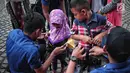 Petugas pemadam kebakaran memasang alat pengaman pada tubuh anak yang akan mencoba wahana flying fox di area Monas, Jakarta, Selasa (1/1). Pengunjung dapat menikmati wahana ini secara gratis. (Liputan6.com/Faizal Fanani)