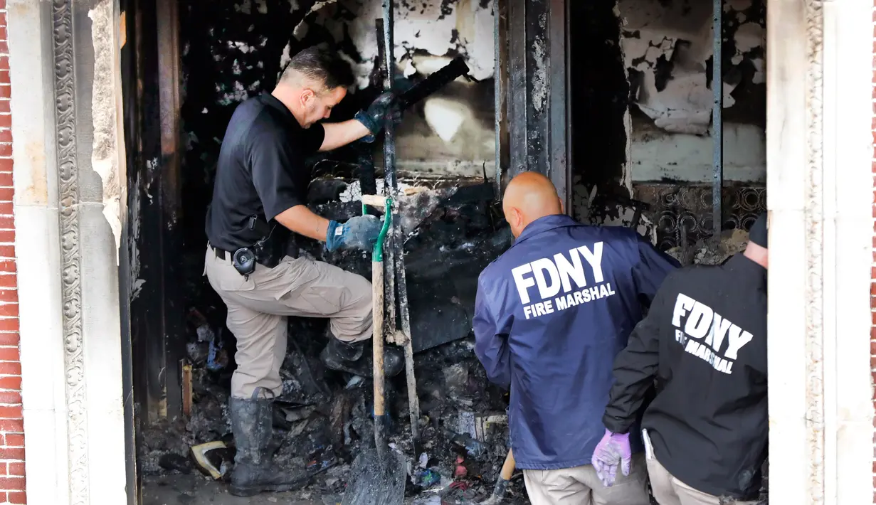 Petugas pemadam kebakaran memeriksa apartemen yang terbakar di kawasan Harlem, New York, Amerika Serikat, Rabu (8/5/2019). Bangunan yang terbakar merupakan kompleks apartemen yang dikelola oleh pemerintah kota. (AP Photo/Richard Drew)