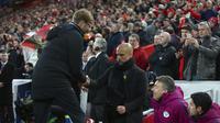 Pelatih Manchester City, Pep Guardiola, tampak lesu saat bersalaman dengan pelatih Liverpool, Juergen Klopp, usai laga perempat final Liga Champions di Stadion Anfield, Rabu (4/4/2018). Liverpool menang 3-0 atas Manchester City. (AFP/Dave Thompson)