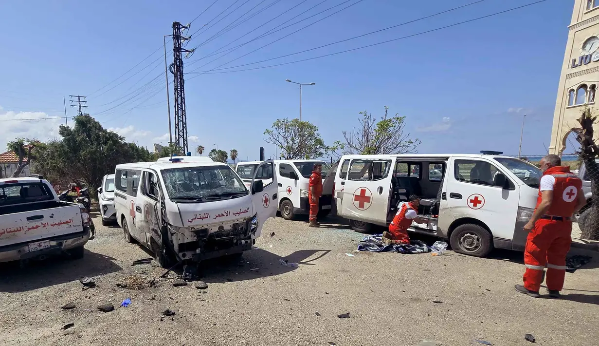 Serangan drone Israel ini mengakibatkan kerusakan serius pada sejumlah ambulans penyelamat milik Palang Merah Lebanon. Tampak dalam foto, para sukarelawan Palang Merah Lebanon memeriksa kerusakan pada kendaraan penyelamat mereka di lokasi serangan pesawat tak berawak Israel yang menargetkan markas mereka di kota Tyre, Lebanon Selatan, Senin 13 April 2026. (Kawnat HAJU/AFP)