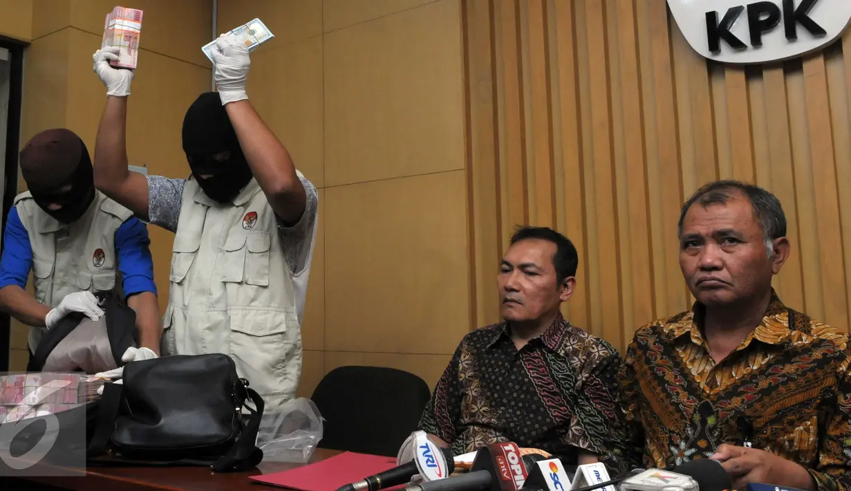 Petugas KPK menunjukkan barang bukti yang diperoleh dari operasi tangkap tangan (OTT) terkait dugaan suap DPRD DKI Jakarta disaksikan pimpinan KPK, Jakarta, Jumat (1/4). (Liputan6.com/Helmi Afandi)