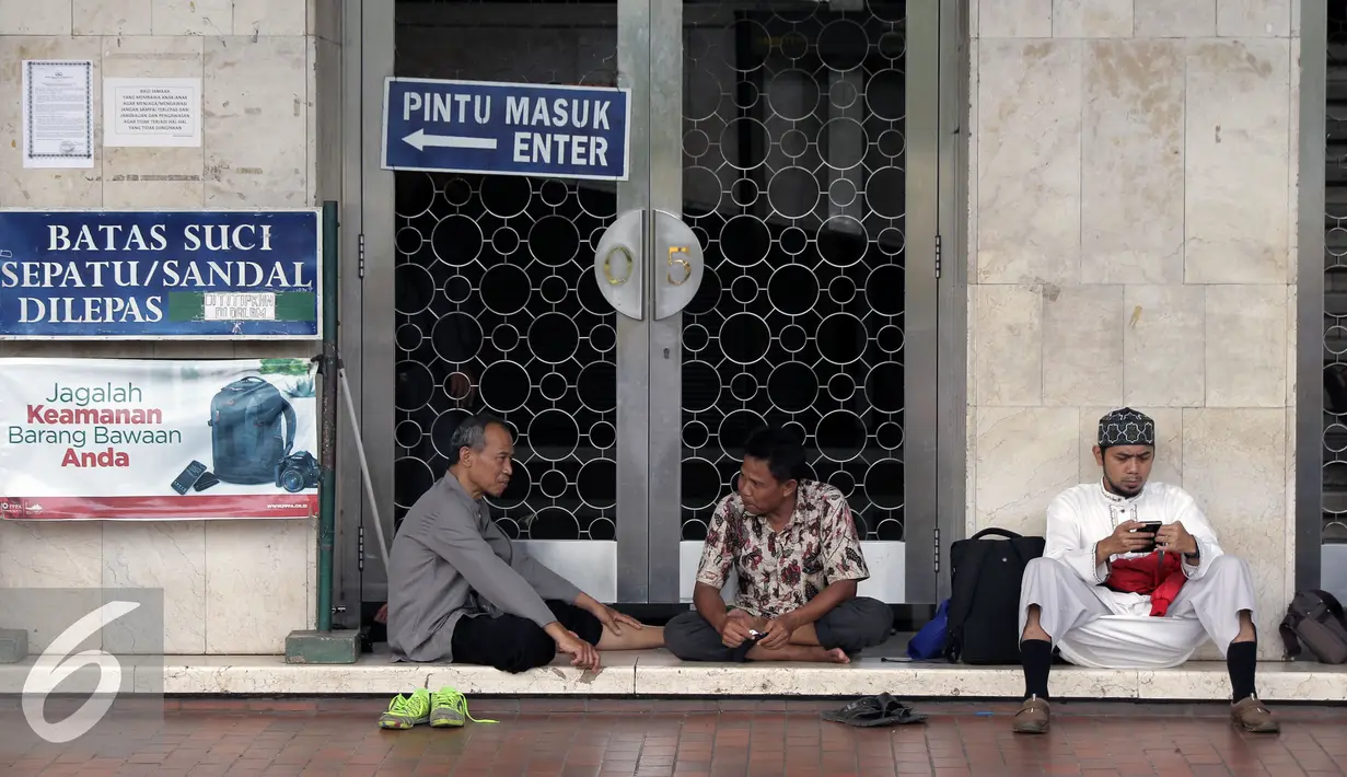 Peserta aksi damai 212 beristirahat di depan pintu masuk Masjid Istiqlal, Jakarta, Kamis (1/12). Rencananya, ratusan ribu umat Islam akan melakukan aksi super damai 212 di halaman Monumen Nasional Jakarta. (Liputan6.com/Helmi Fithriansyah)