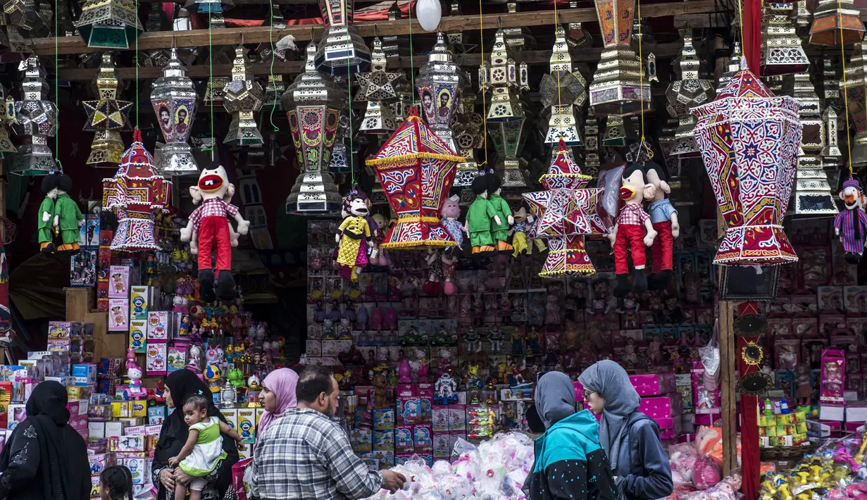 Sejumlah warga mengunjungi toko yang menjual pernak-pernik bertema Mohamed Salah di Kairo, Mesir, Senin (30/5/2018). Menjadi pahlawan baru bagi rakyat Mesir, pernak pernik Mohamad Salah laris manis. (AFP/Khaled Desouki)