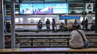 Penumpang menunggu kedatangan KRL di Stasiun Manggarai, Jakarta, Selasa (12/1/2021). Selama PSBB di DKI mulai 11-25 Januari, PT Kereta Commuter Indonesia (KCI) memangkas jadwal operasional KRL menjadi pukul 04.00 WIB hingga 22.00 WIB guna menekan penularan Covid-19. (merdeka.com/Iqbal Nugroho)