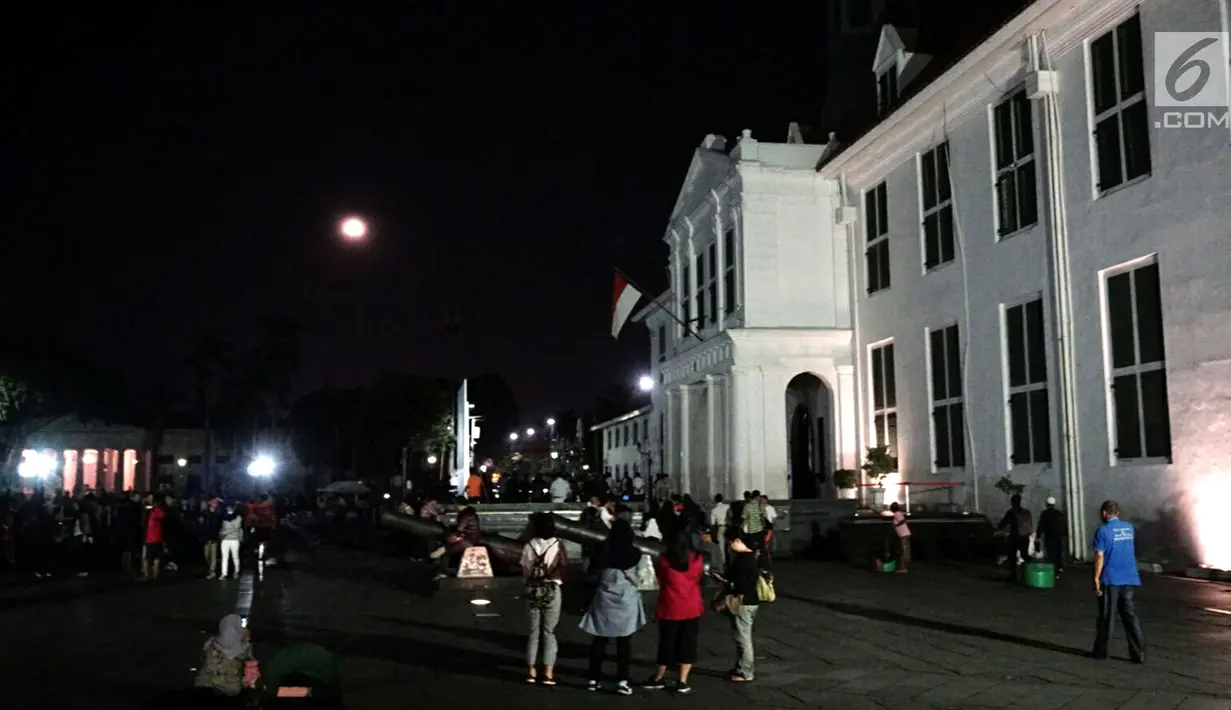 Warga menyaksikan gerhana bulan total di Kota Tua Jakarta, Rabu (31/1). Kegiatan tersebut dilakukan di halaman Museum Fatahillah. (Liputan6.com/Arya Manggala)