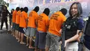 Petugas berjaga di samping tersangka saat rilis di Polda Metro Jaya, Jakarta, Jumat (20/4). Jajaran Polda Metro Jaya berhasil menyita 39.834 botol miras hasil operasi razia miras oplosan selama periode 1 hingga 19 April 2018. (Liputan6.com/Arya Manggala)