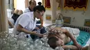 Seorang pasien menerima terapi beka api di sebuah rumah sakit di Shenyang di provinsi Liaoning, China timur laut (7/8). Terapi bekam api digunakan untuk menyegarkan sirkulasi darah. (AFP Photo/Str/China Out)