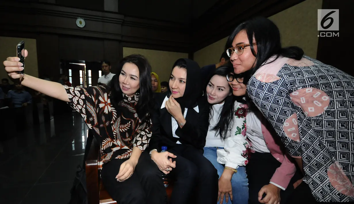 Bupati nonaktif Kutai Kartanegara, Rita Widyasari (kedua kiri) berswafoto bersama kerabatnya jelang mengikuti sidang perdana di Pengadilan Tipikor, Jakarta, Rabu (21/2). Sidang mendengar dakwaan Jaksa Penuntut Umum. (Liputan6.com/Helmi Fithriansyah)