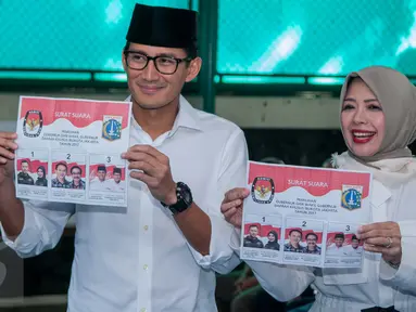 Calon Wakil Gubernur DKI Sandiaga Uno bersama istrinya,  Nur Asia, menunjukkan surat suara sebelum mencoblos pada Pilkada DKI 2017 di  TPS 01 Kelurahan Selong, Jalan Daha 4, Kebayoran Baru, Jakarta Selatan, Rabu (15/2). (Liputan6.com/Gempur M Surya)