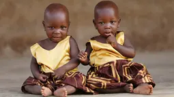 Si kembar identik, Taiwo Adejare dan Kehinde Adejare berpose untuk sebuah foto di Igbo Ora, Negara Bagian Oyo, Nigeria pada 4 April 2019. Saking banyaknya anak kembar yang dilahirkan, Igbo Ora dijuluki sebagai "ibu kota kembar dunia". (REUTERS/Afolabi Sotunde)