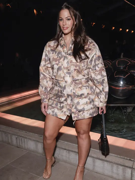 <p>Ashley Graham menghadiri koleksi siap pakai Isabel Marant Fall/Winter 2023-2024 yang dipresentasikan Paris, Prancis, 2 Maret 2023. Model berusia 35 tahun ini menampilkan kaki panjangnya dalam pakaian cetak kargo, menonjolkan lekuk tubuhnya indah, dan menambahkan beberapa inci ke tubuhnya dengan sepasang sepatu bertali cokelat serta tas tangan hitam yang apik. (Vianney Le Caer/Invision/AP)</p>