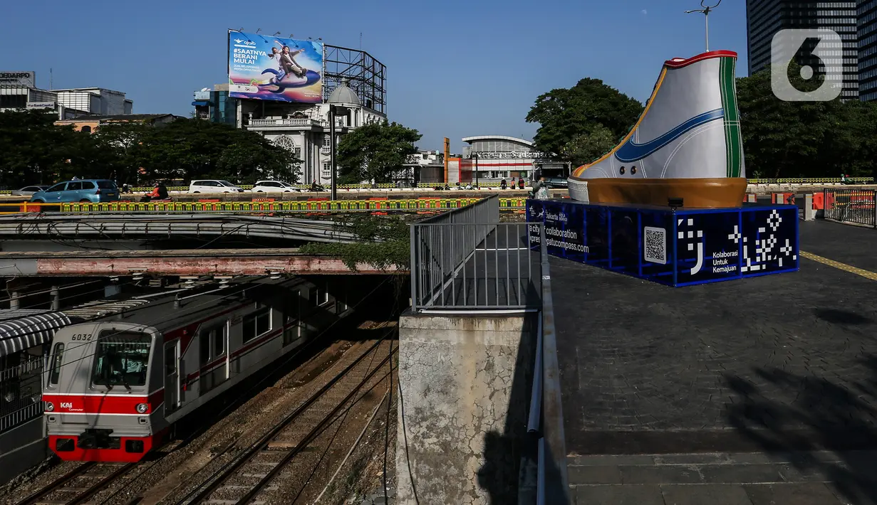 Sebuah KRL melintas di dekat instalasi karya seni kreasi pelaku ekonomi kreatif, kawasan Stasiun BNI City, Jakarta, Jumat (17/9/2021). Pemasangan instalasi karya seni kreasi itu bentuk dukungan dan motivasi agar ekonomi kembali bangkit setelah terdampak pandemi COVID-19. (Liputan6.com/Johan Tallo)