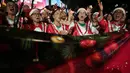 Beberapa di antaranya ada yang mengenakan topi Santa, tanduk rusa, hingga lampu hias di kepala. Tampak dalam foto, Umat Kristiani menyanyikan lagu-lagu Natal di Jakarta, Indonesia, Selasa, 23 Desember 2025. (AP Photo/Dita Alangkara)