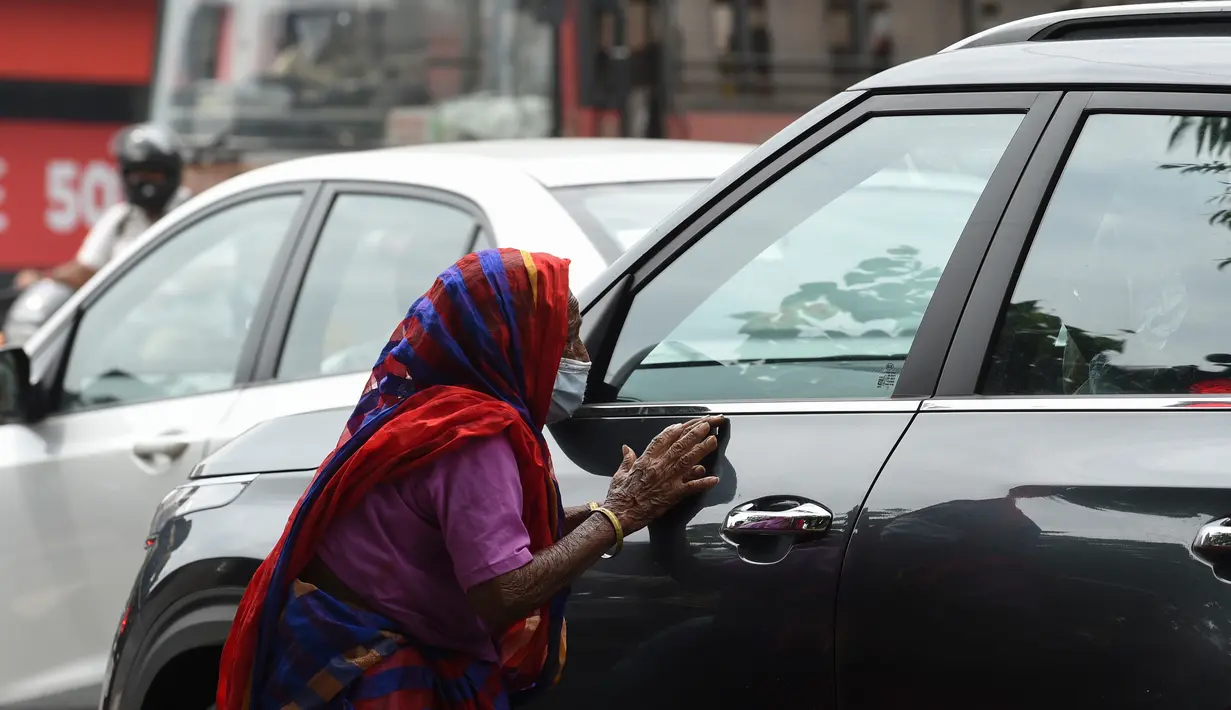 Lansia meminta sedekah di persimpangan lalu lintas di Ahmedabad, Senin (17/8/2020). Kasus kematian akibat Covid-19 di India telah melewati 50 ribu pada Senin (17/8), dengan kawasan pedesaan dan kota kecil yang lemah dalam sistem kesehatan menjadi daerah terdampak paling parah. (SAM PANTHAKY/AFP)