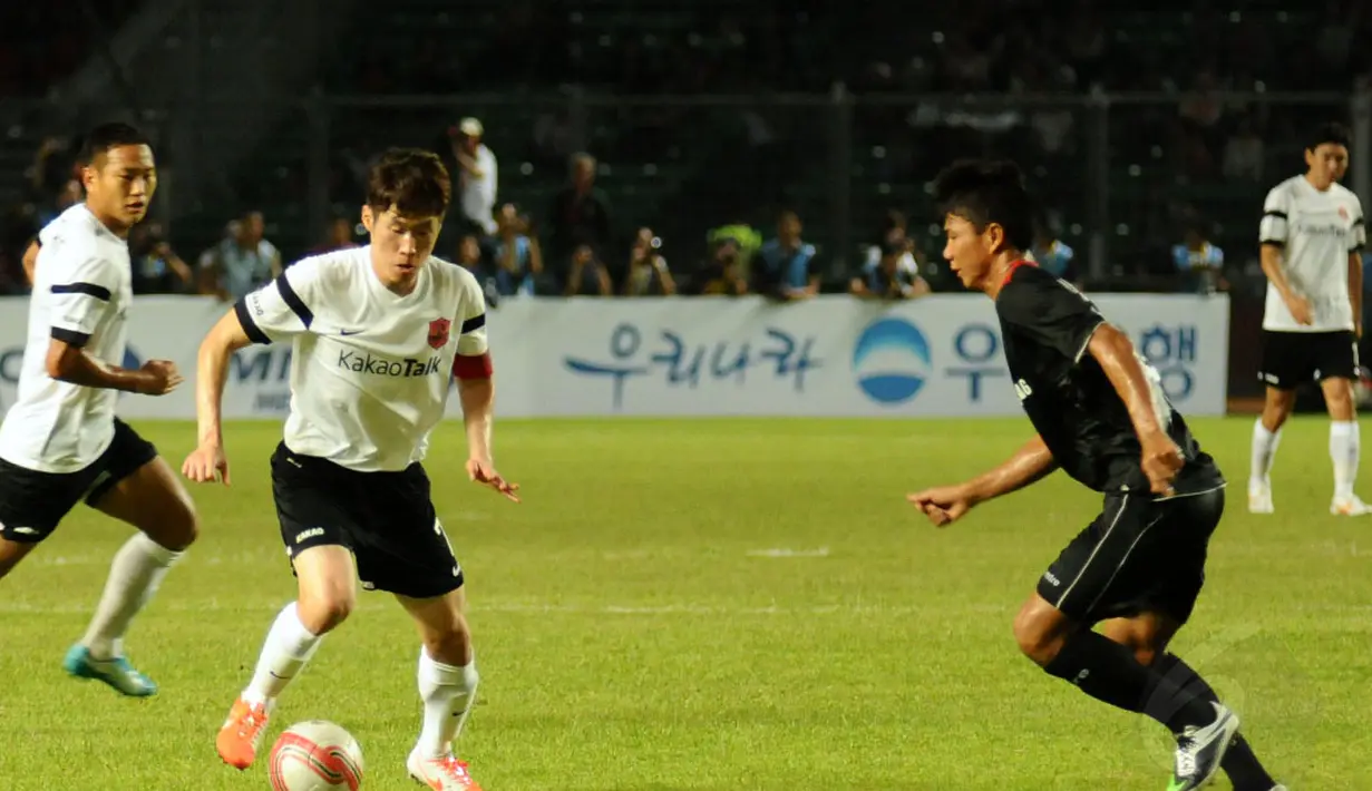 Park Ji Sung (JS & Friends - kiri) mencoba melewati hadangan A Juprianto (Indonesia All Star) dalam laga persahabatan di Stadion GBK Jakarta, (2/6/2014). (Liputan6.com/Helmi Fithriansyah) 