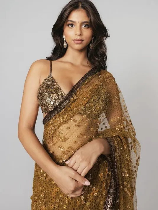 <p>Suhana Khan sukses memerankan film berjudul The Archies. Dalam unggah Instagramnya, ia kerap tampil mengenakan pakaian khas India yaitu sari. Seperti ia tampil serba coklat berpayet. (@suhanakhan2)</p>