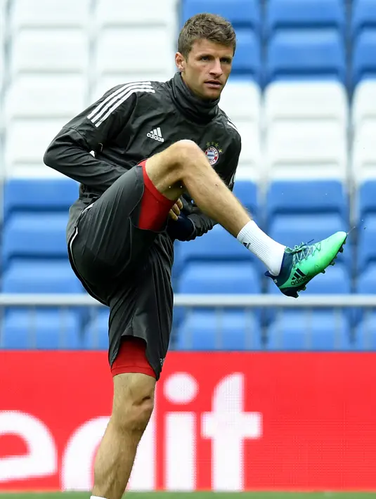 Penyerang Bayern Munchen, Thomas Mueller melakukan pemanasan selama sesi latihan di Stadion Santiago Bernabeu di Madrid (30/4). Pada leg pertama Munchen takluk atas Madrid 2-1 di Allianz Arena, Jerman.  (AFP Photo/Christof Stache)