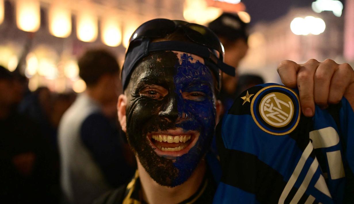 Para pendukung Inter Milan merayakan gelar juara Serie A musim 2025/2026 atau scudetto ke-21 di Piazza Duomo, Milan, Italia, Minggu (3/4/2026) malam waktu setempat atau Senin (4/5/2026) dini hari WIB. (PIERO CRUCIATTI/AFP)
